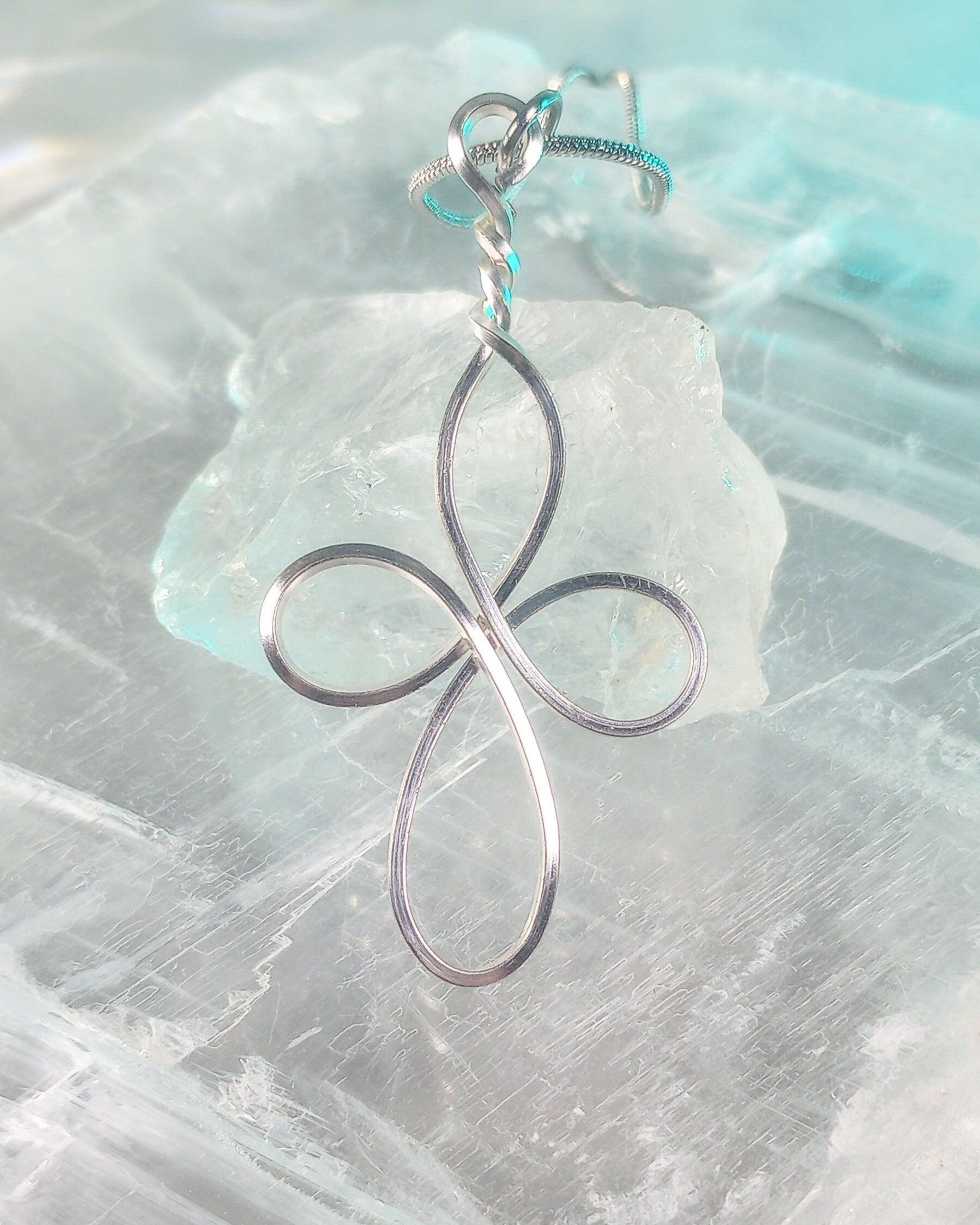 Silver cross pendant on a clear crystal stone